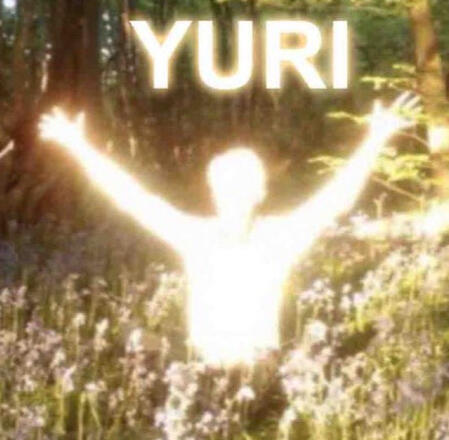 A person glowing with divine light stands in a field of waist length tall grass with their hands outstretched towards the word YURI in the air above their head.